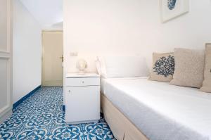 卡普里塞莱尼酒店的一间设有两张床的卧室,铺有蓝色和白色的地板