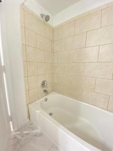 华盛顿Lovely Remodeled 2bdrm Basement Home的浴室设有白色浴缸,铺着瓷砖。