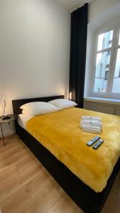托伦Central Rooms Apartment的一间卧室配有一张带黄色毯子的大床