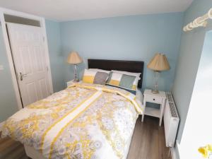 巴林罗布22 Town Place的一间卧室配有一张黄色和白色的被子。