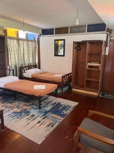 太平MyDusun Chalet, Taiping, Perak, Malaysia的带三张床、桌子和架子的房间