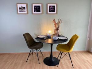 兰河畔马尔堡Apartment Lahnblick的一张桌子、三把椅子和一张桌子及蜡烛