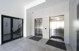 弗罗茨瓦夫Milo Aparthotel的大楼内带两部电梯的走廊