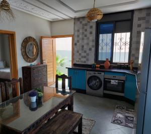 提兹尼特Magnifique villa face à l'océan的厨房配有洗衣机和桌子