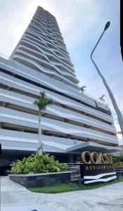 马尼拉Coast Residence 4026 PENTHOUSE 1 Bedroom Condo with Wifi & Netflix的一座大建筑,前面有棕榈树