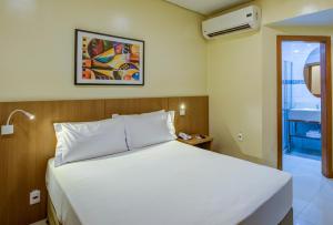 里约热内卢Rio Aeroporto Hotel Galeão的卧室配有白色的床和窗户。