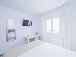 托雷德本纳贾尔邦Cubo's Hostal William's Sunny 3 with Breakfast的白色的卧室配有白色的床和镜子