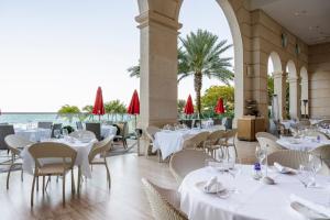 迈阿密海滩Acqualina Resort and Residences的一间设有白色桌椅的海洋餐厅
