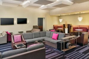 皇后区纽约肯尼迪机场万怡酒店的带沙发和椅子的客厅以及电视