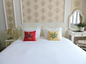 胡志明市Chez Lotus Rose的一张带三个枕头的白色床
