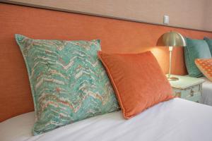 吉马良斯Dom José Alojamentos by Guestify的一张带橙色和绿色枕头的床和一盏灯