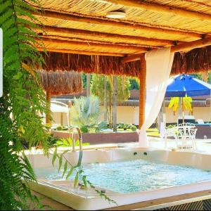苏马雷Sumaré Park Hotel的度假村内的热水浴池,配有遮阳伞
