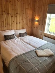 霍尔斯沃德吕尔海克拉冒险山林小屋的卧室内的一张大床,设有木墙