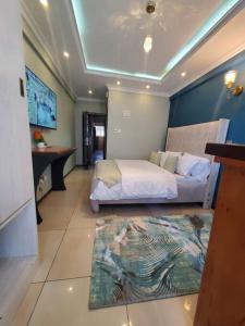 内罗毕Cozy Studio Stay Kilimani Valley Acarde Area的卧室配有一张床,地板上铺有地毯