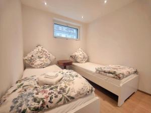 因特拉肯FeWo Interlaken的一间小卧室,配有两张床和窗户