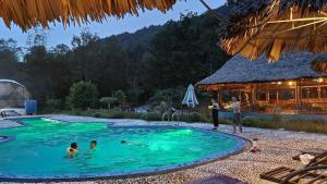 吉婆岛Woodstock Jungle Camp的一群人在度假村的游泳池里