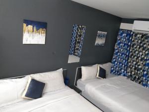 钦奈Silver Cloud Hotel Sholinganallur的墙上画作的房间里设有两张床