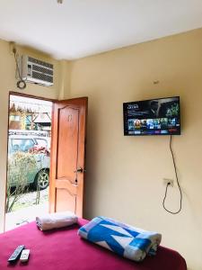 蒙塔尼塔Hostal Tierra y Mar的卧室配有一张床铺,墙上配有电视