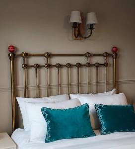 彼得斯菲尔德The Cricketers Inn的一张带白色枕头和金属床头板的床