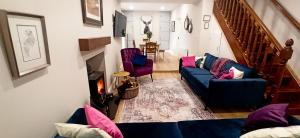 戈尔韦Atlantic Way Cottage的客厅配有蓝色的沙发和紫色的椅子