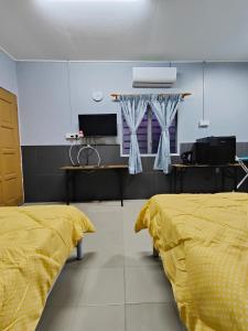 马六甲TBE Room2stay at Jalan BR3的配有黄色床单的客房内的两张床
