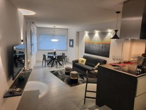 奥里斯塔诺la suite oasi di relax e comfort IUN R1091的厨房以及带沙发和桌子的客厅。