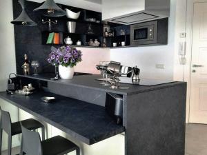 奥里斯塔诺la suite oasi di relax e comfort IUN R1091的厨房里设有黑色的柜台,上面有鲜花