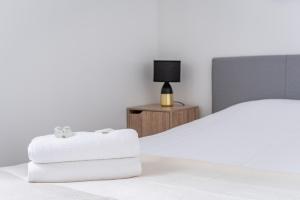 希尔蒂盖姆Le Fournil - WiFi - Séjournez à proximité de tout的一间卧室配有床和带毛巾的床头柜。