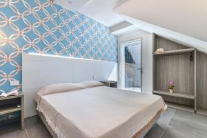 拉科纳Villa Serena vista mare的一间卧室设有一张床和蓝色的墙壁
