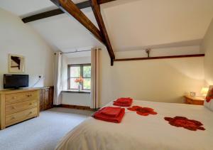 Bratton FlemingButton Barn的一间卧室配有一张大床,上面有红色的毛巾