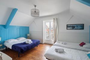 圣马洛Villa Sainte Geneviève的配有2张床的蓝色和白色墙壁客房