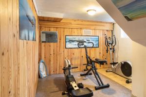 圣马洛Villa Sainte Geneviève的配有木镶板和健身器材的健身房