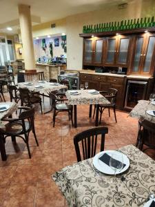 La PueblanuevaHostal Restaurante CASA FRAN的一间带桌椅的餐厅和一间厨房