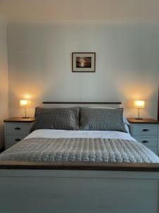 SwordaleDairy Cottage的一间卧室配有一张大床,桌子上放着两盏灯