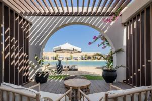 阿莱曼Le Sidi - A TLT Signature Hotel的户外庭院设有拱门和桌椅。