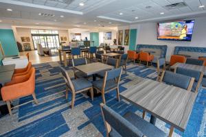 拉斐特拉斐特机场温德姆集团温盖特酒店的用餐室配有桌椅和平面电视。