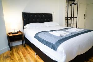 伦敦Centra Studios的一间卧室配有一张大床和黑色床头板