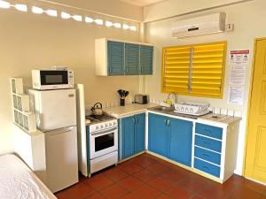 Carnbee VillageSherwood Park Apartments的厨房配有蓝色橱柜和白色冰箱