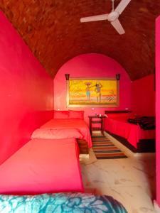阿斯旺Kamel House的粉红色客房内的2张床
