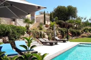 阿尔坎塔里利亚Villa Girassol met zwembad的一个带躺椅的游泳池以及一座房子