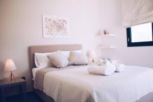 拉格尼西Summer Villa Lagonissi的白色卧室,配有带毛巾的床
