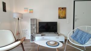 尼基季To Helidoni Apartment & Gardens的客厅配有电视和2把椅子