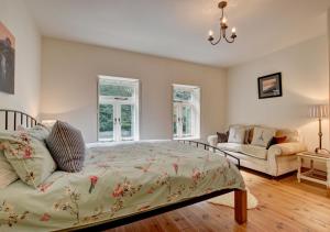 林茅斯River Cottage的一间卧室配有一张床、一张沙发和窗户。