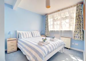 林茅斯River View的蓝色的卧室设有床和窗户