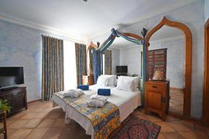 阿尔布费拉博阿维斯塔酒店 - 仅限成人的一间卧室配有一张大床和电视
