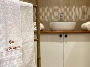 锡拉奥Gîte le Fouquet的毛巾挂在带水槽的浴室内