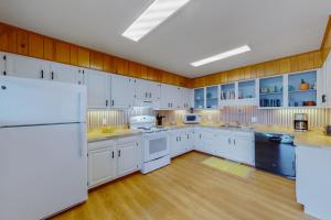 哈特勒斯Sea Shanty 960的一间铺有木地板并配有白色家电的大厨房