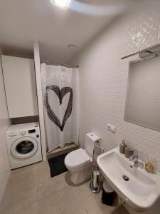 里加Valentine's apartment的浴室配有卫生间、盥洗盆和洗衣机。
