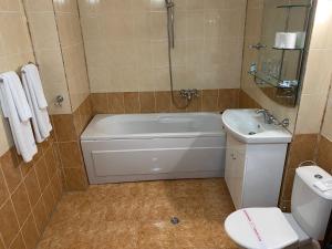 希典卡门耐克酒店的带浴缸、卫生间和盥洗盆的浴室