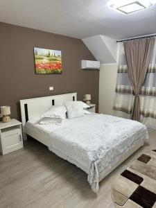 Complex Turistic Cetatea Drencova的一间卧室设有床、两张桌子和一扇窗户